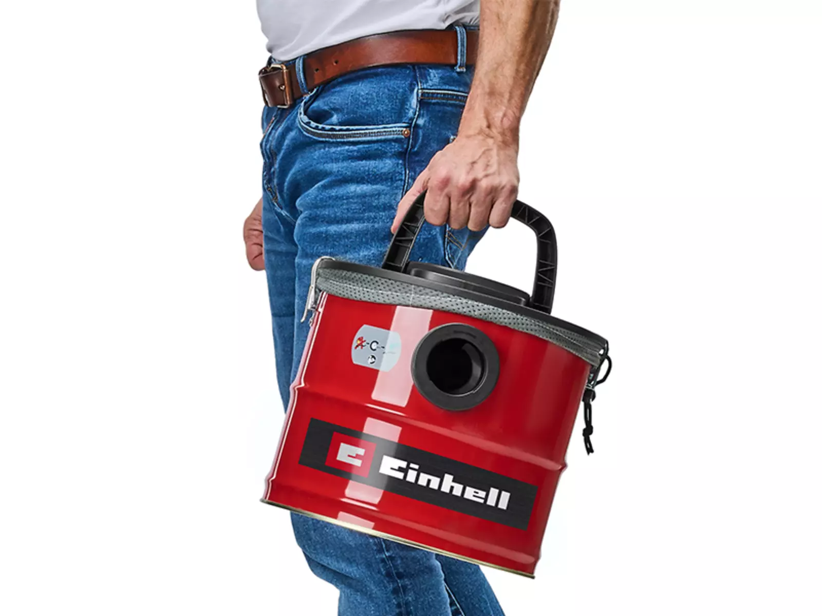 Чоловік несе пилосос для попелу Einhell TC-AV 1830 D, тримаючись однією рукою за верхню ручку для перенесення.