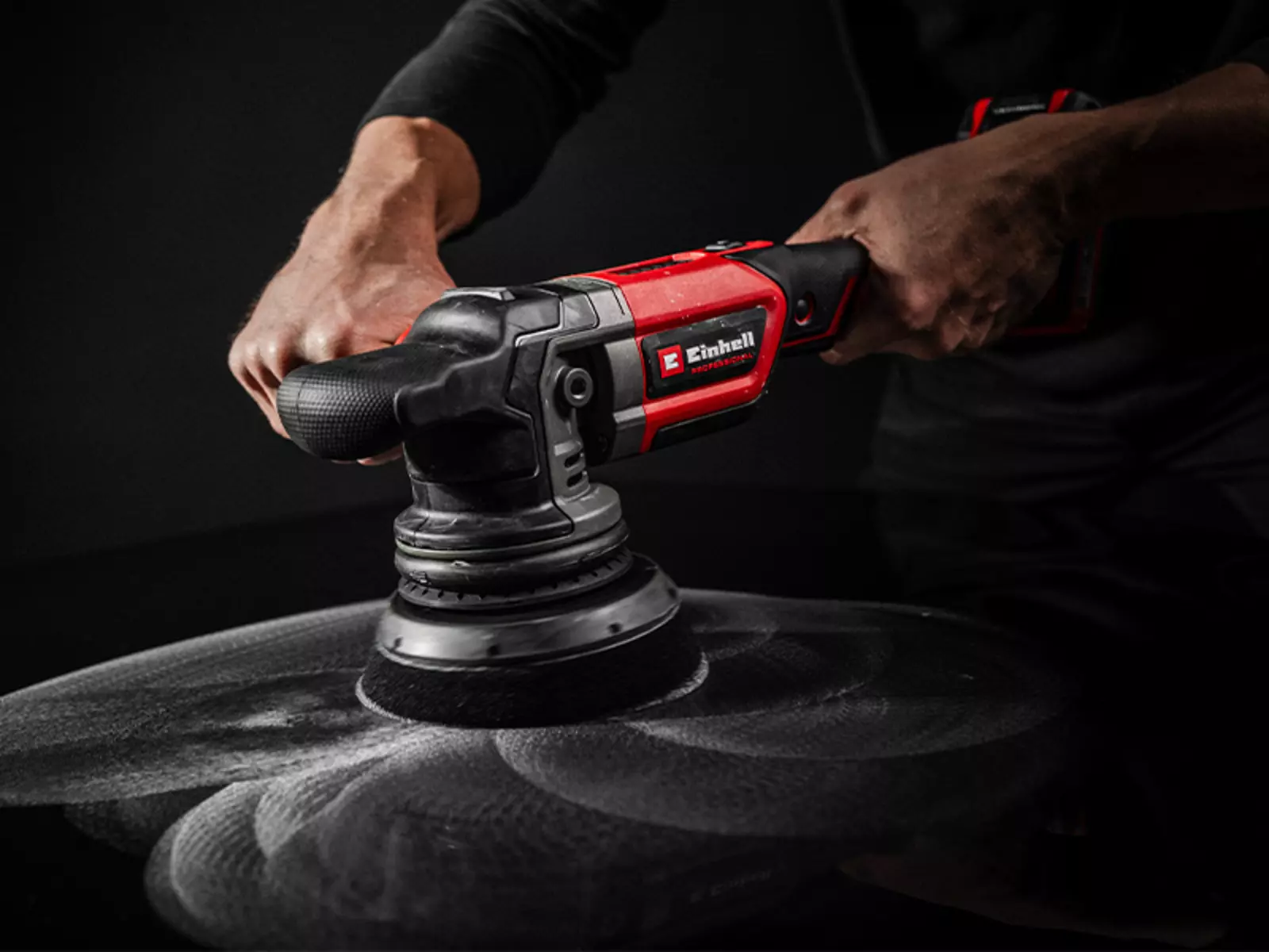 Акумуляторна ексцентрикова полірувальна машина Einhell CP-EP 18/125 Li BL-Solo використовується з полірувальною губкою на темній пофарбованій поверхні.