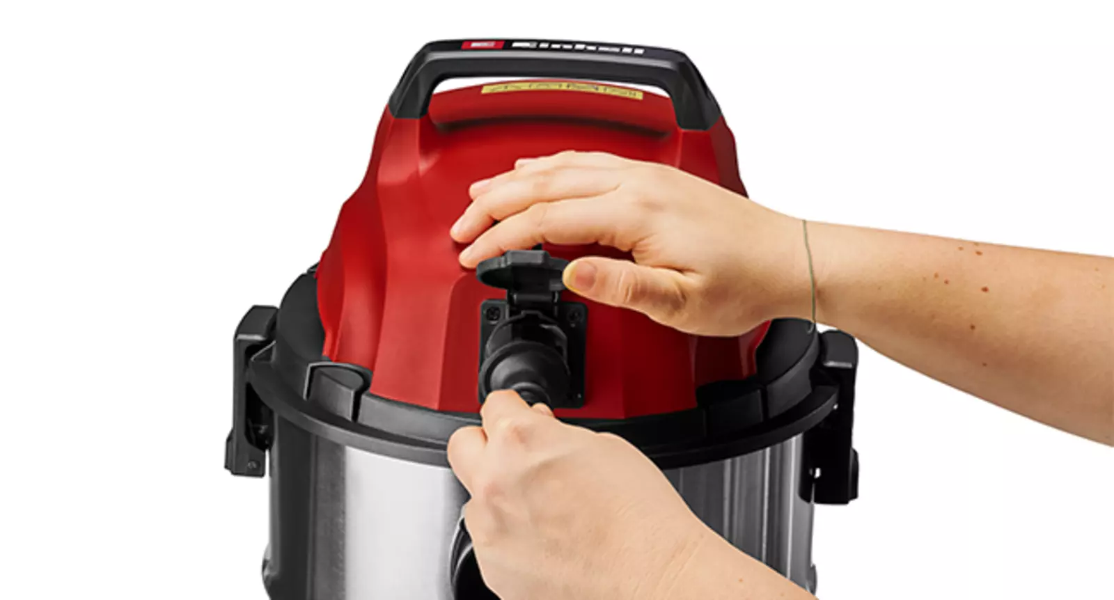 Рука вставляет вилку в автоматическую розетку пылесоса для влажной и сухой уборки Einhell TC-VC 3055 SA.