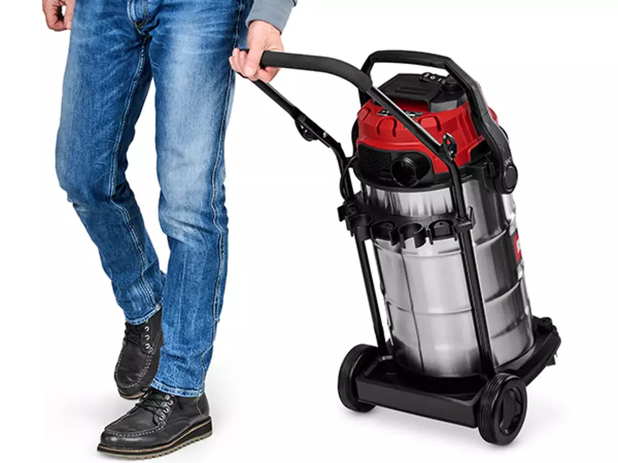 Чоловік встановлює пилосос для вологого/сухого прибирання Einhell TE-VC 4090 SACL на колеса за допомогою великої ручки для перенесення.