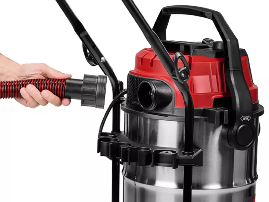 Користувач вставляє всмоктувальний шланг у з'єднання пилососа для вологого/сухого прибирання Einhell TE-VC 4090 SACL.