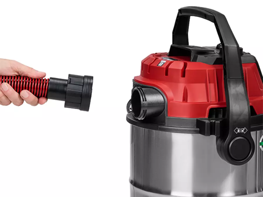 Пользователь вставляет шланг в отверстие для вентилятора на задней панели пылесоса для влажной и сухой уборки Einhell TE-VC 2580 SACL.