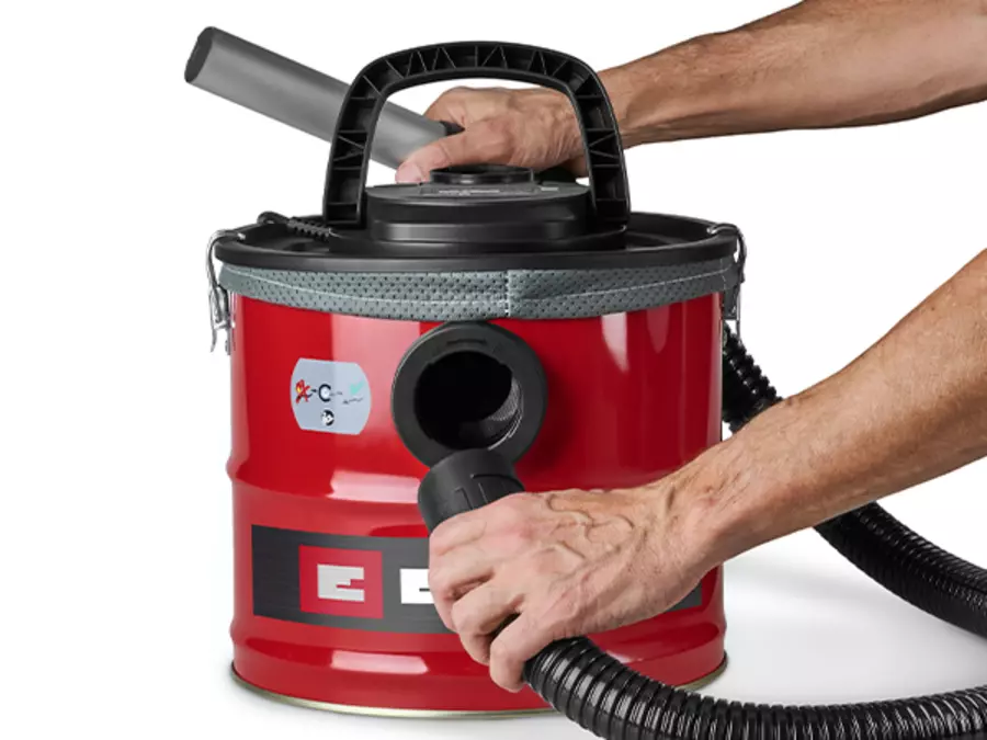 Користувач керує пилососом для попелу Einhell TC-AV 1830 D з підключеним всмоктувальним шлангом.