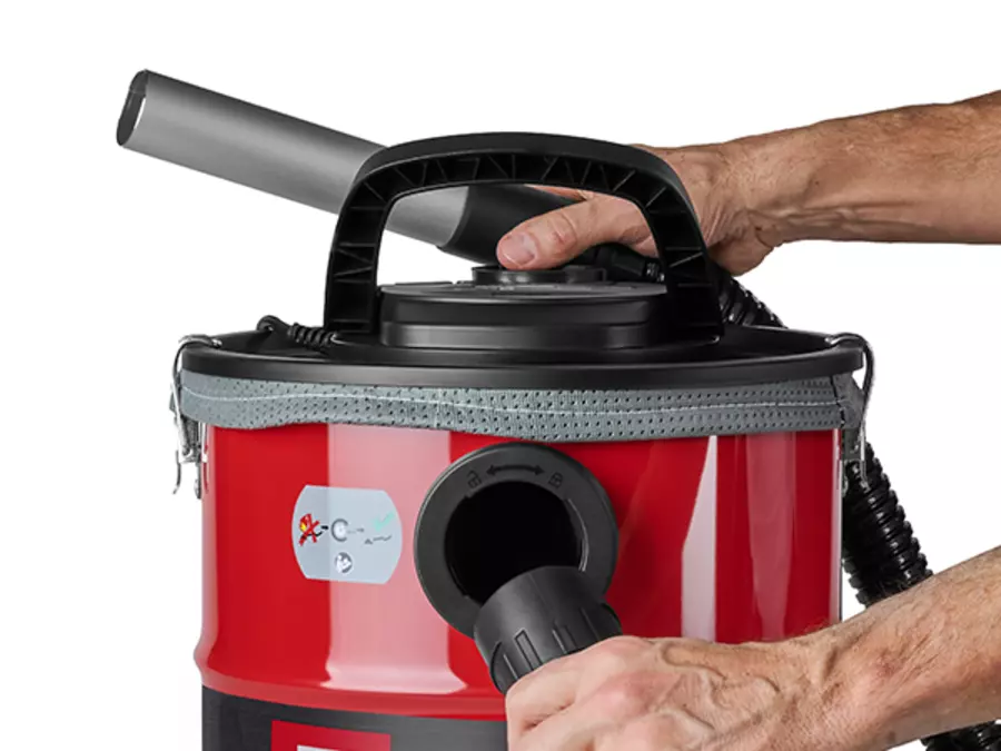 Користувач керує пилососом для попелу Einhell TC-AV 2032 DW з підключеним всмоктувальним шлангом.