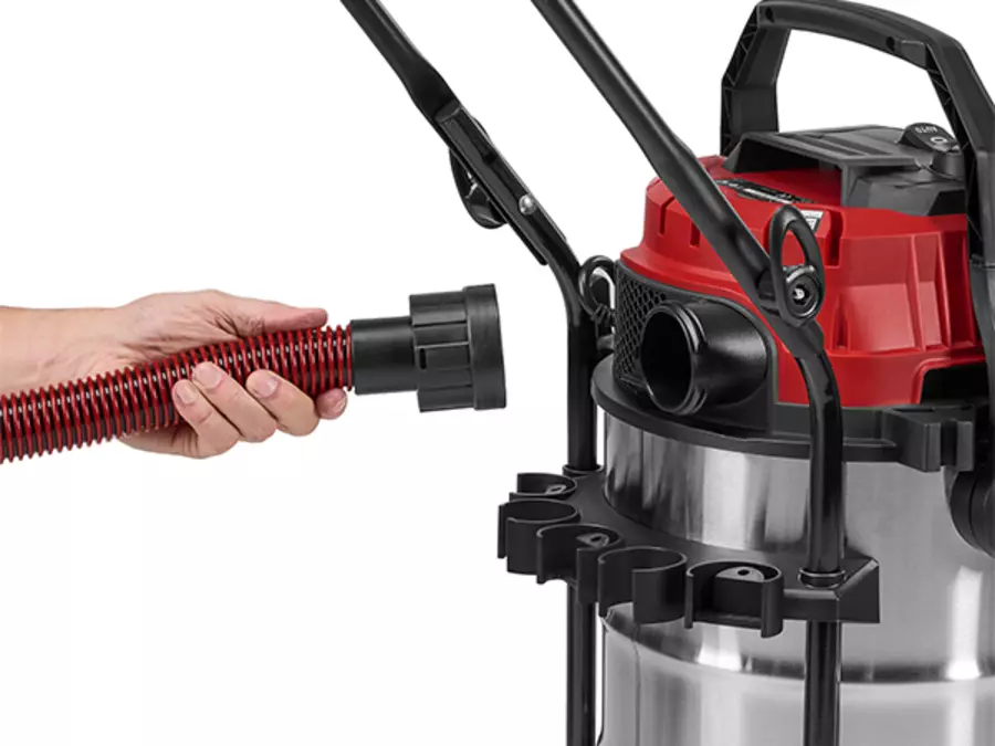 Пользователь вставляет шланг в отверстие для воздуходувки на задней панели пылесоса для влажной и сухой уборки Einhell TE-VC 3080 SACL.