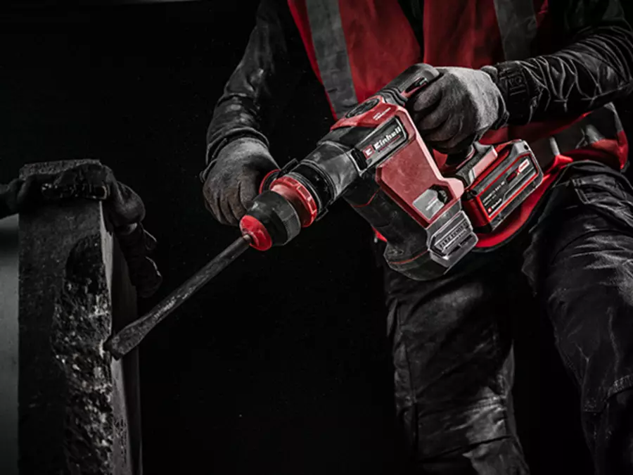 Робочий у захисному одязі використовує відбійний молоток Einhell TP-DH 18/4 Li BL для роботи з бетоном.